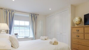A hotel room with a bed, a dresser, a globe, and a television. - 3 bedroom accommodation in Buckley St (Buckley St)