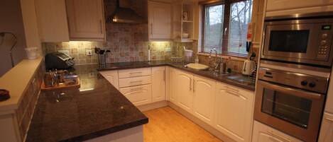 Ovn, oppvaskmaskin, høy barnestol og kjøkkenutstyr