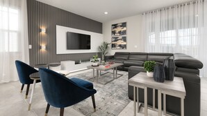 A modern living room with a sofa, coffee table, and blue chairs. - Dream Residence Equipped with a Game Room, Snooker Table, PlayStation 5 (Davenport)