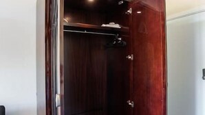 Un vestidor con puerta de madera y barra para colgar.