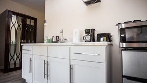 Una cocina moderna con armarios blancos, electrodomésticos de acero inoxidable y encimera de mármol.