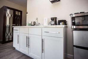 Fridge, microwave, coffee/tea maker, cookware/dishes/utensils