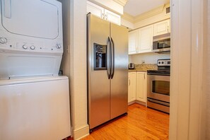 A compact kitchen with a stainless steel refrigerator, a built-in oven, and a microwave. - Lakeside View 2bed-2bath|Saddlebrook Resort Access (Wesley Chapel)