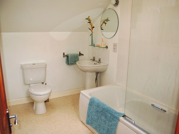 A bathroom with a toilet, sink, and bathtub.