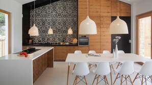 A modern kitchen with a central island, wooden paneling, and a patterned backsplash. - Awarded Design Villa Olea, Luxury Villa with heated pool & Seaview (Klimno (Krk))