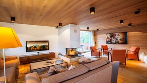 A modern living room with a fireplace, comfortable seating, and artwork on the walls. - Delicious dining with a view of Hohe Tauern National Park,close to the ski lift (Bramberg am Wildkogel)