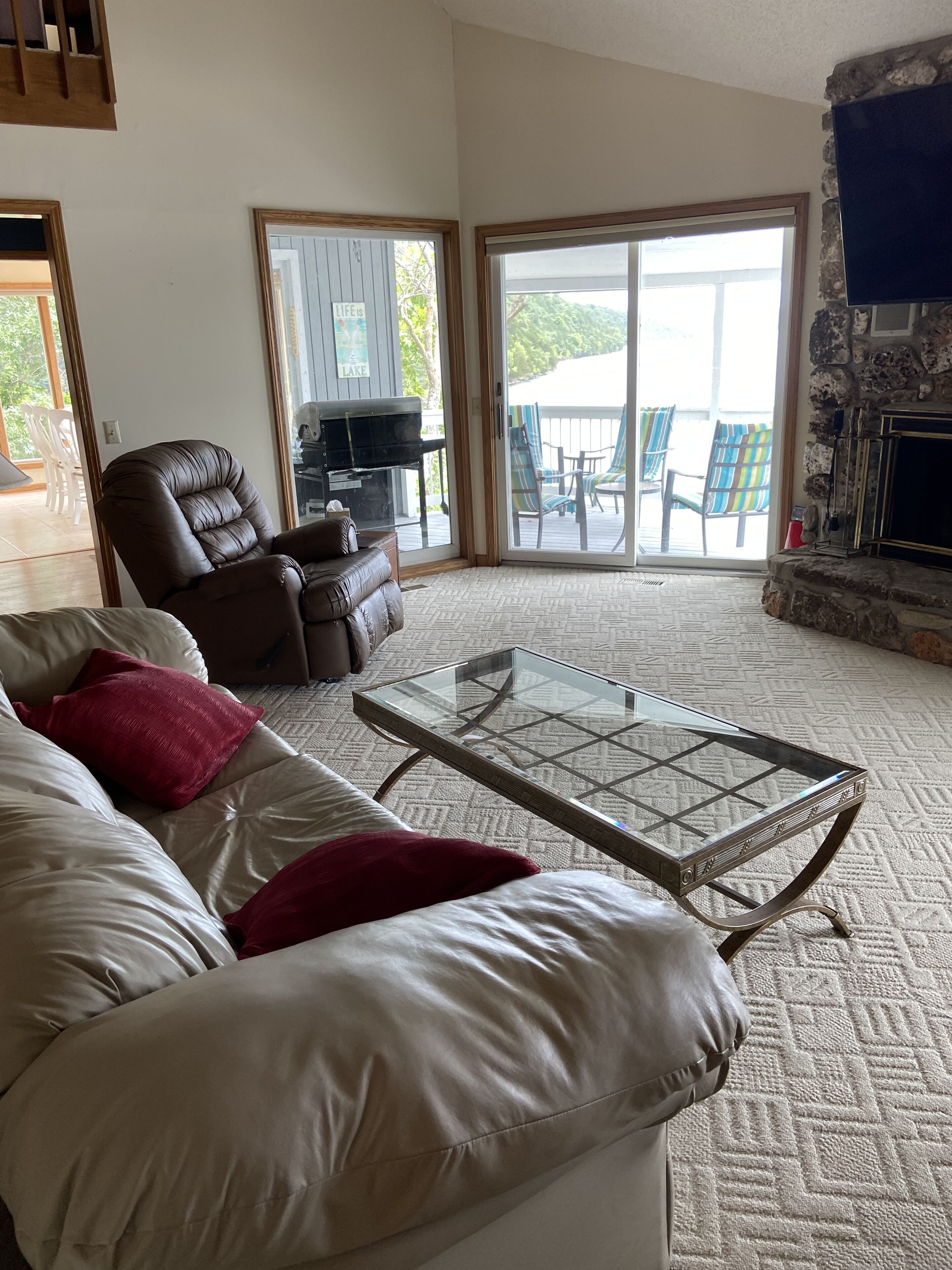 Lower-level family room with wood burning fireplace. TV replaced- way larger TV