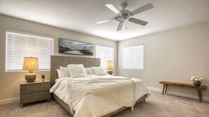 A bedroom with a bed, bedside lamps, a nightstand, a ceiling fan, and a painting on the wall. - Modern, Fully Renovated 4 Bedroom House (Las Vegas)