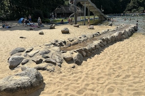 Une plage de sable avec de gros rochers et un mur de pierres.