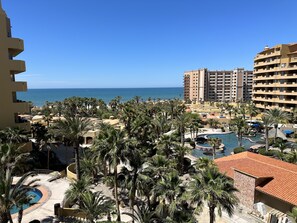 A resort with multiple buildings, a swimming pool area, and a view of the ocean. - Bella Sirena Beachfront Condo With Beautiful View of Sea of Cortez (Puerto Peñasco)