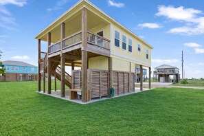 A two-story house with a balcony, a covered porch, and a fenced yard.