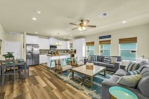 A spacious living area with a sofa, coffee table, and dining table.