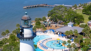 A lighthouse, a swimming pool, and a pier extending into the water.