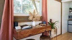 A wooden desk with a vase of pampas grass, books, and a small plant. - The Carson at Ridgeview. Asheville rental! Luxury Glamping! (Alexander)