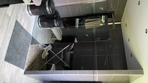 Een moderne badkamer met een grote spiegel, zwart-witte tegels, een handdoekhouder en een toilet.