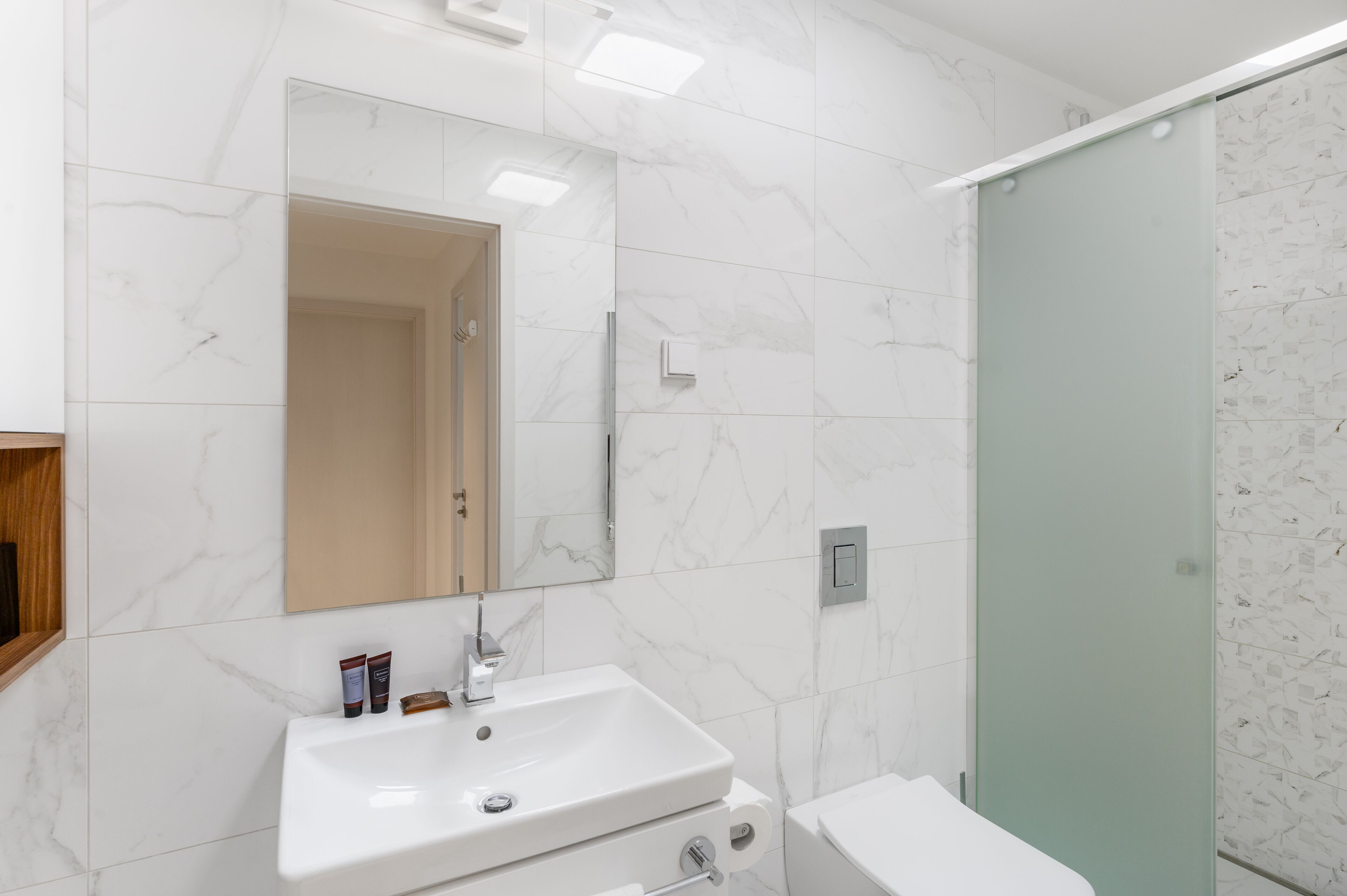 Ein Badezimmer mit Waschbecken, Spiegel und Duschkabine.