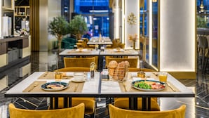 A dining area with tables set for breakfast, featuring plates of food, drinks, and decorative items. - Emerald Downtown Suites (Budapest)