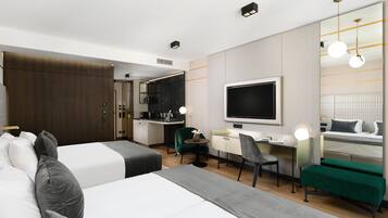 A hotel room with two beds, a desk, a chair, a TV, and a mirror.