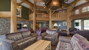 A spacious lodge interior with a stone fireplace, multiple leather sofas, and a high wooden ceiling. - Ski-in / Ski-out 2Bed 2Bath Sunstone Lodge Condo at Little Eagle Express (Mammoth Lakes)
