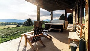 An outdoor patio with a wooden table, chairs, and a grill. - Amazing 3-level home.  Perfect for 3-generation family visits.  Sunsets & elk. (Angel Fire Resort)