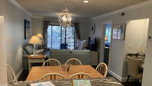 A dining area with a granite table, chairs, a chandelier, and a sofa in the background. - Fall / Snow Bird Special• 6-Min Walk to  Beach • Pool, Tennis -Gated–Hilton Head (Hilton Head)