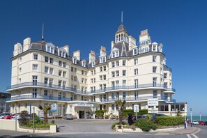 A large, multi-story hotel with a classic architectural style, featuring balconies and a prominent entrance. - Queens (Eastbourne)