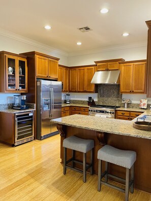 A modern kitchen with wooden cabinets, stainless steel appliances, and a granite countertop. - Wine country retreat within walking distance of restaurants, wineries and more (St. Helena)