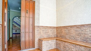 A corner of a room with a wooden door, a stone wall, and a tiled floor. - 5 bedroom beautiful home in Algamitas (Algamitas)