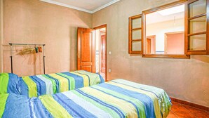 A hotel room with two beds, a wooden door, a window, and a tiled floor. - 5 bedroom beautiful home in Algamitas (Algamitas)