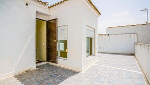 A small, single-story building with a tiled patio, a door, and a window. - 5 bedroom beautiful home in Algamitas (Algamitas)