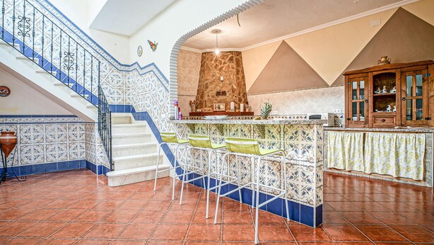 A spacious kitchen with a tiled backsplash, a stone chimney, and a wooden cabinet. - 5 bedroom beautiful home in Algamitas (Algamitas)