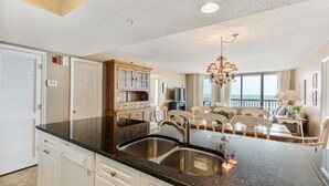 A modern kitchen with a central island, built-in cabinetry, and a view to the living area.