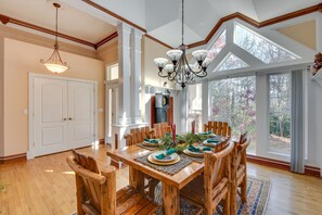 A dining area with a wooden table set for six, surrounded by wooden chairs. - Hot Tub, Arcade & Casino! Blue Ridge Mtn Mansion (Blairsville)