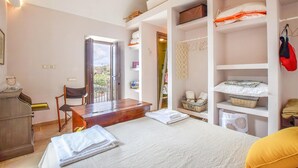 Ein Schlafzimmer mit Bett, Schreibtisch, Stuhl und Kleiderschrank.