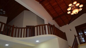 A multi-level interior with wooden railings, a curved staircase, and a chandelier. - Villa Vinses In Hikkaduwa (Hikkaduwa)