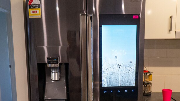A stainless steel refrigerator with a built-in ice dispenser and a digital display. - FAMILY HOLIDAY HOME (Redbank Plains)
