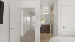 A hotel room with a bed, a bathroom with a sink, and a hallway leading to other rooms. - Perfect Escape - Brand New St. George Townhome (St. George)