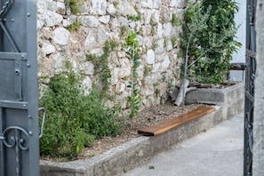Discover a charming, historic alleyway with a rustic bench for rest and a glimpse into a traditional setting.