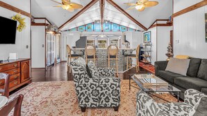 A spacious living room with high ceilings, wooden beams, and a large window. - Silo House (Fairhope)