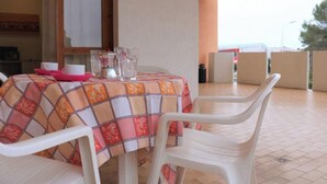 A table with a checkered tablecloth, white plastic chairs, and a pink tray. - Apartment With Large Terrace (San Michele al Tagliamento)