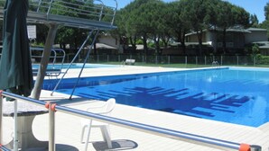 A swimming pool with a diving board and a lifeguard stand. - Apartment With Large Terrace (San Michele al Tagliamento)