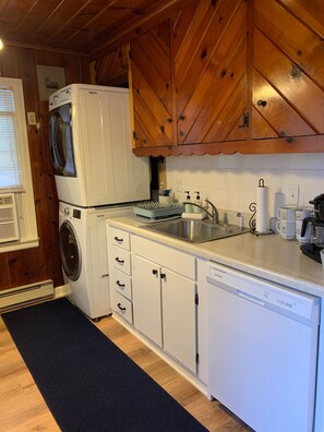 Efficient kitchen with dishwasher, double-door oven, and stainless steel sink.