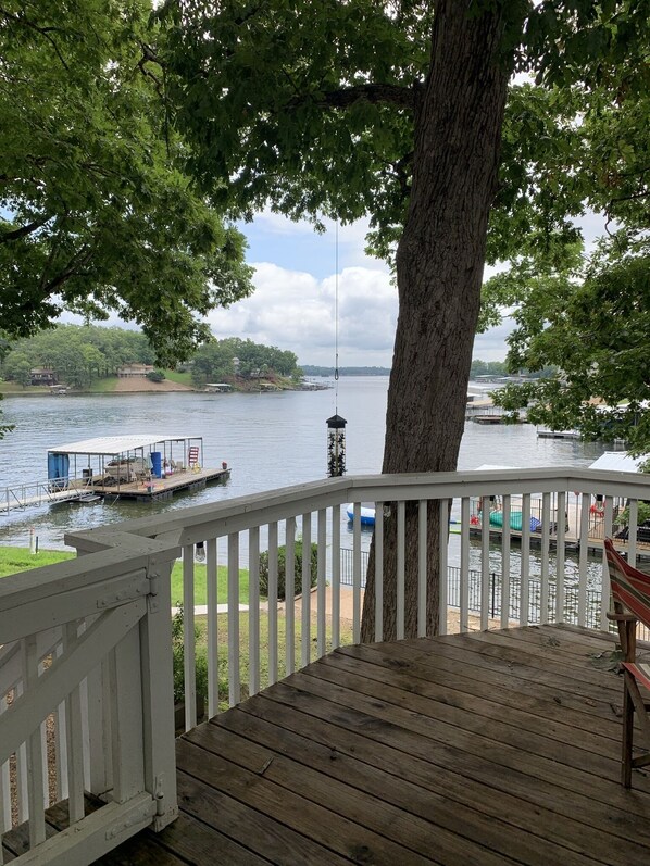 Enjoy serene waterfront views from this deck overlooking a tranquil body of water.