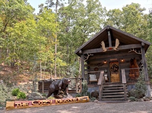 Eine rustikale Holzhütte mit einer Holzfassade, einer Hirschkupp und einer Elchskulptur davor.