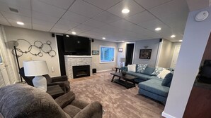 A living room with a fireplace, a sofa, a recliner, and a coffee table. - Centrally Located in Heart of Sister Lakes, Michigan (Dowagiac)