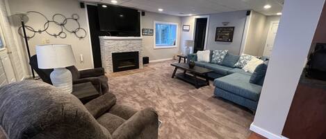 A living room with a fireplace, a sofa, a recliner, and a coffee table.