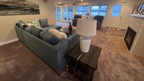 A living room with a blue sofa, a lamp, and a fireplace. - Centrally Located in Heart of Sister Lakes, Michigan (Dowagiac)