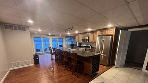 A modern kitchen with wooden cabinets, stainless steel appliances, and a bar area. - Centrally Located in Heart of Sister Lakes, Michigan (Dowagiac)