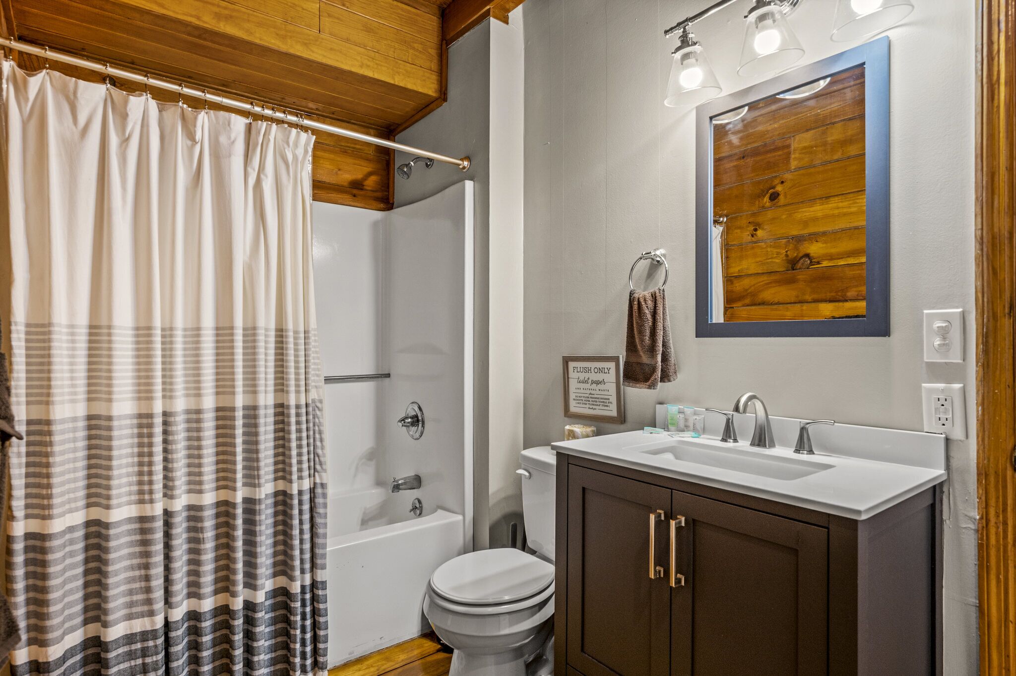 Une salle de bain équipée d’une douche, de toilettes et d’un meuble-lavabo avec un miroir.