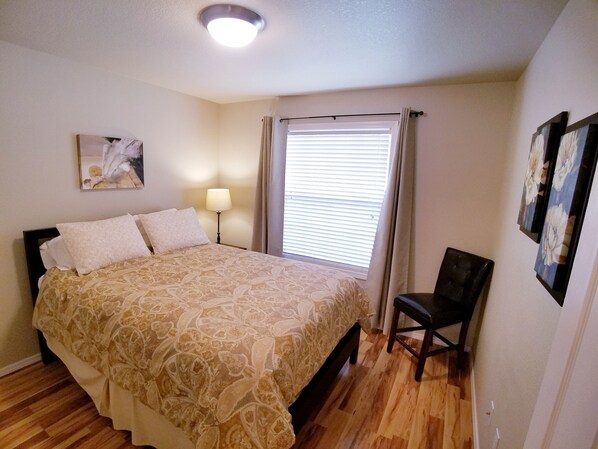 A bedroom with a bed, a chair, a bedside lamp, a window with blinds, and a ceiling light. - Beautiful Home in Golf Course Community - 3 Bedroom plus Den (Meridian)